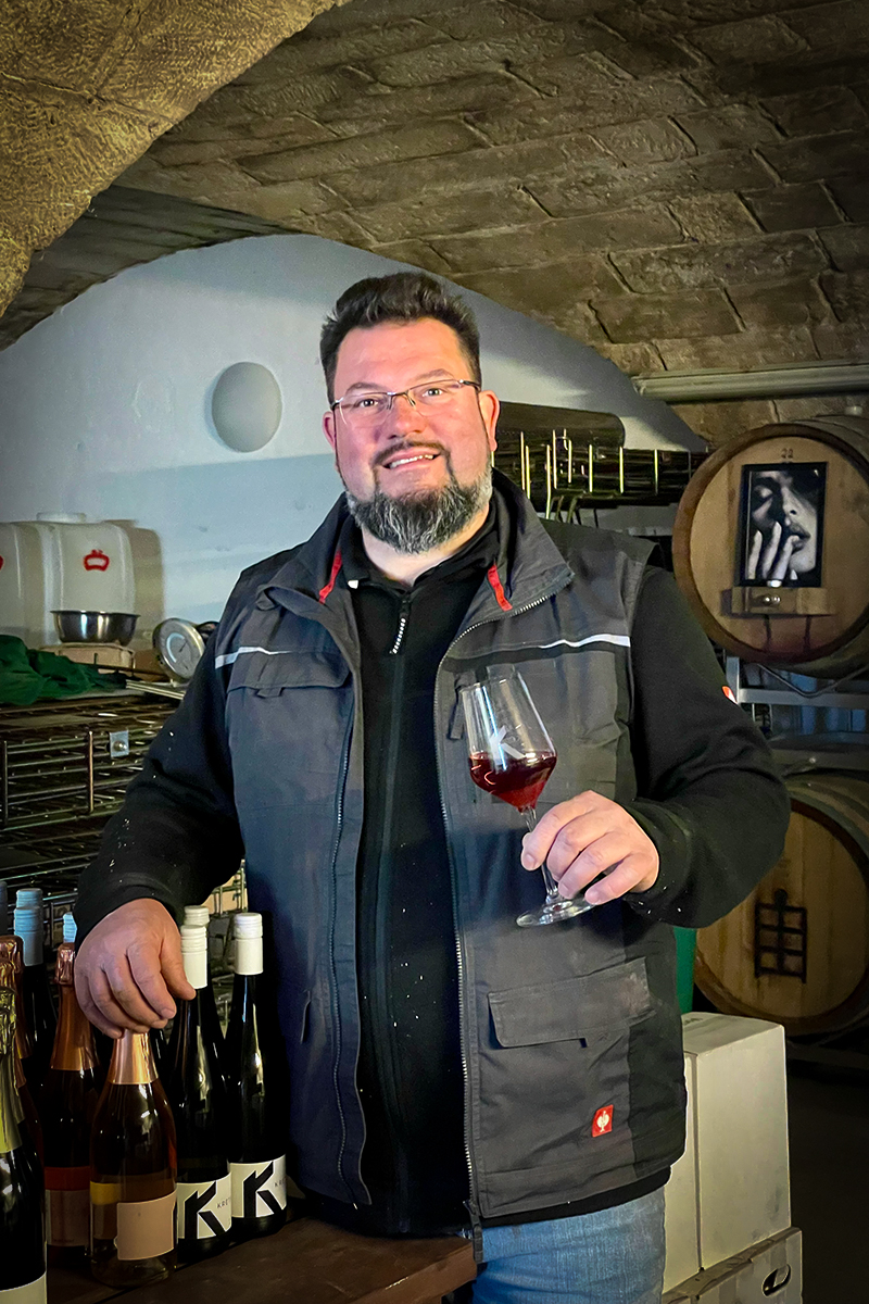 Andreas R. Kretschko im Keller mit einem Weinglas